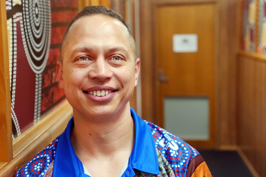 An image of a young Indigenous doctor, smiling at the camera.