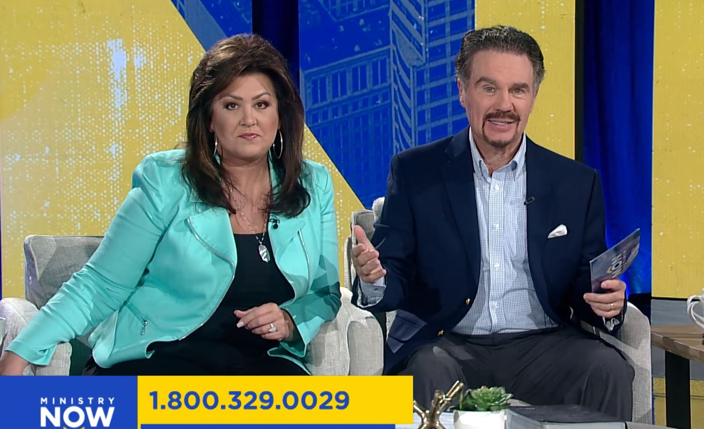 Joni and Marcus Lamb sitting on a TV couch speaking to the camera.