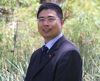 Un hombre con traje mira a la cámara y sonríe.