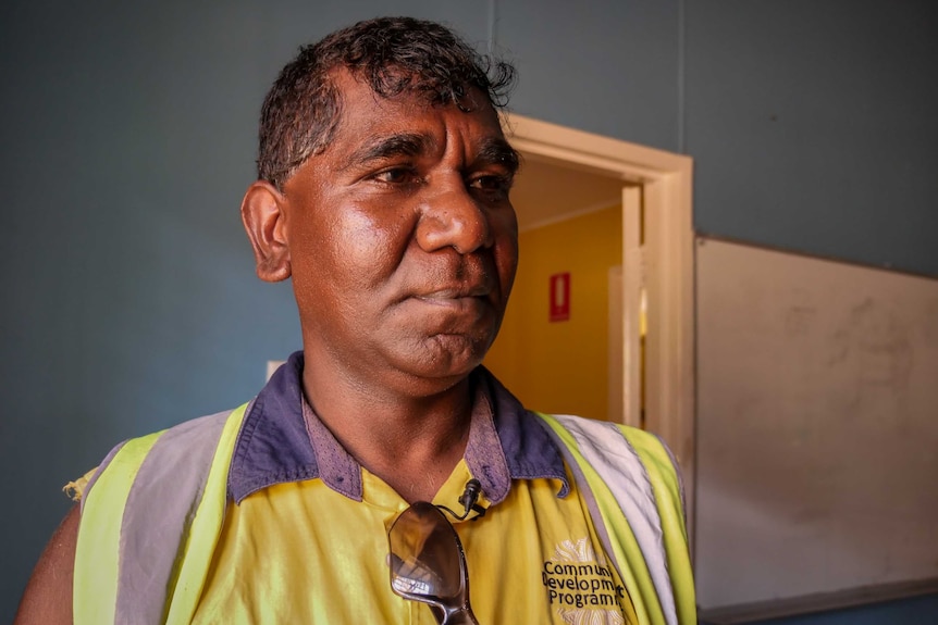 A mid shot of Shannon Killer from Looma posing for a photo indoors in hi-vis clothing.