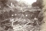 Miners pictured, in black and white, working in a gully.