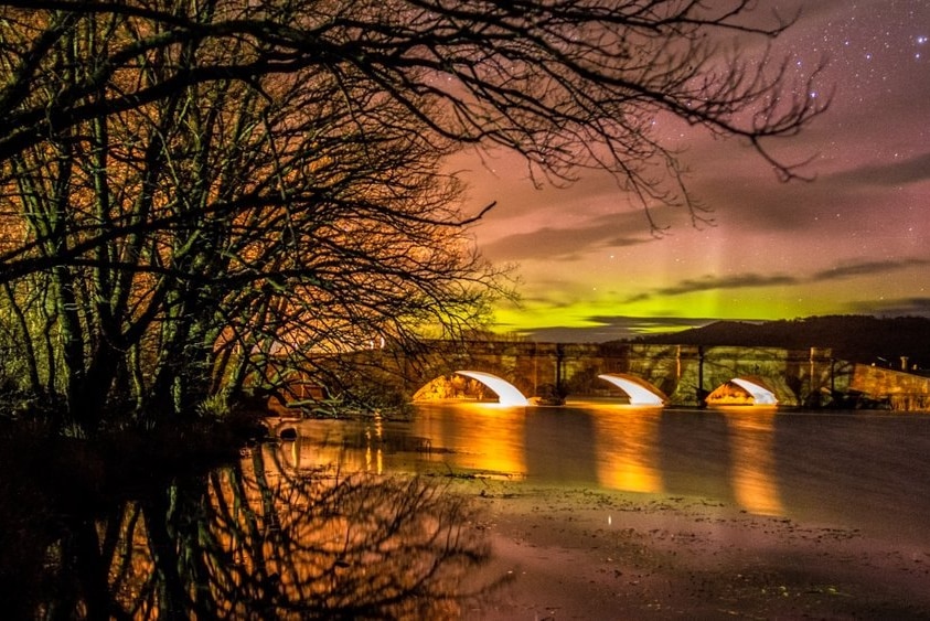 Historic Ross bridge in Tasmania's Midlands with Aurora Australis in background