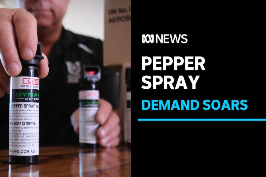 Pepper Spray, Demand Soars: A man holding cannisters of pepper spray on a table.