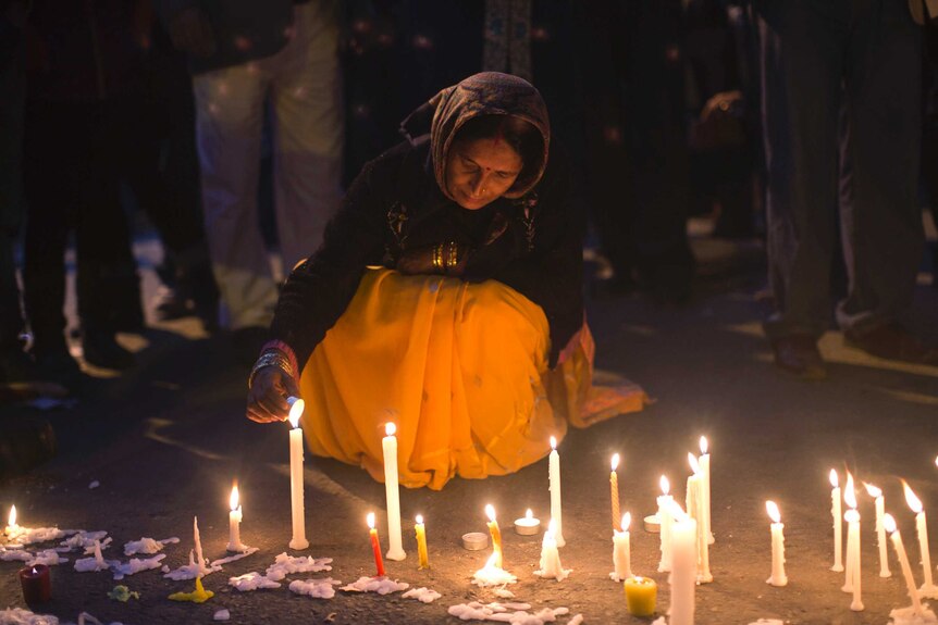 Indian woman lights a candle for gang-rape victim
