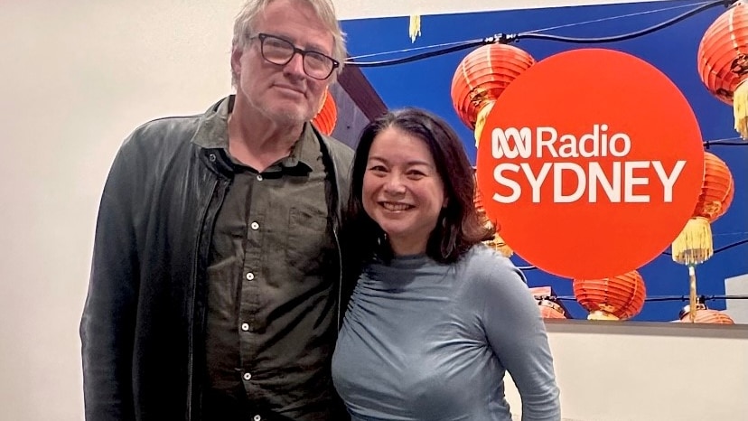 Andrea Ho and Australian musician and songwriter, David Bridie, smiling for a photo in the ABC Radio Sydney office.