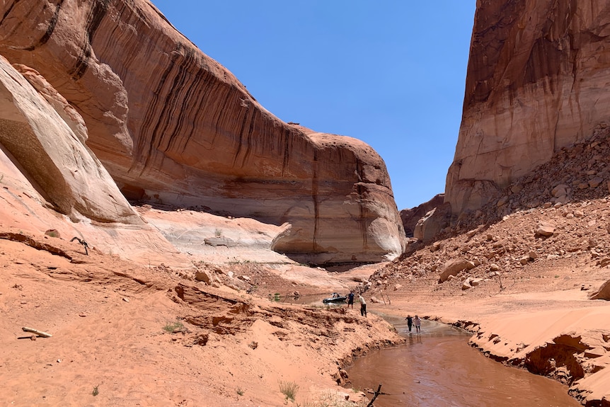 People walking up a stream.