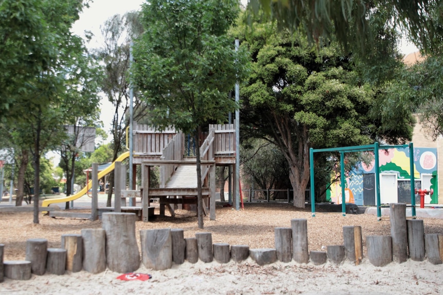 An empty playground at a primary school, with a sandpit in the foreground.