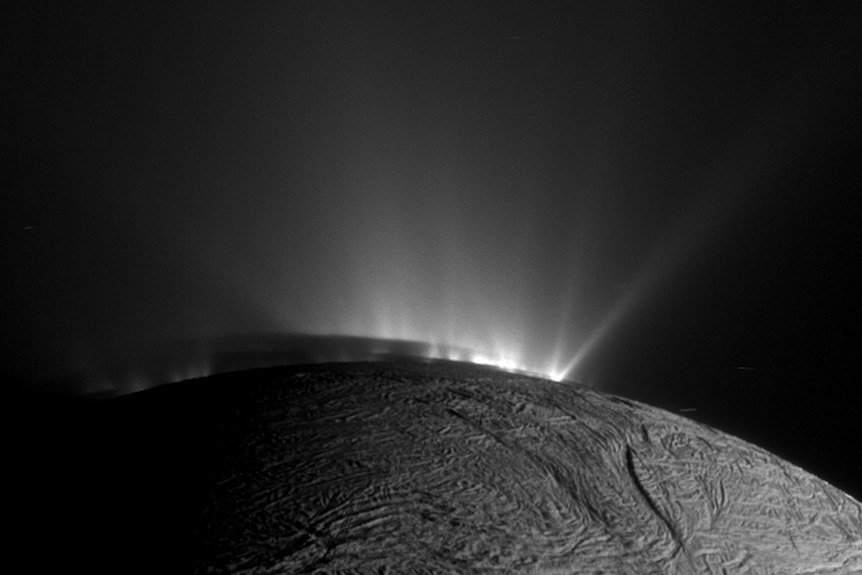 Ice plumes coming from surface of Enceladus.