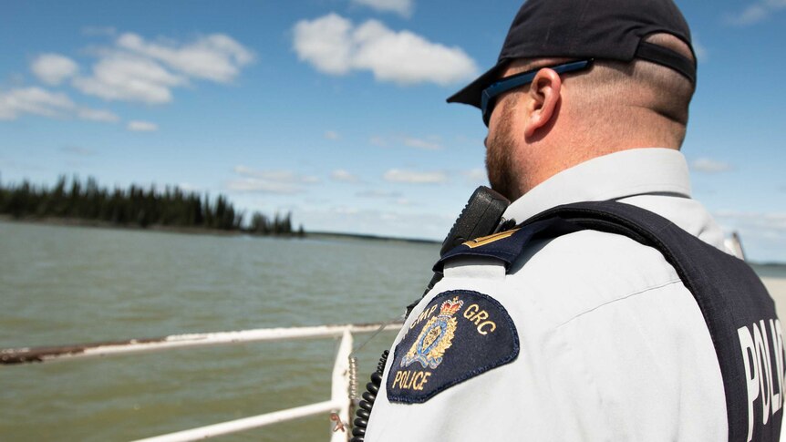 A police officer looking at a river