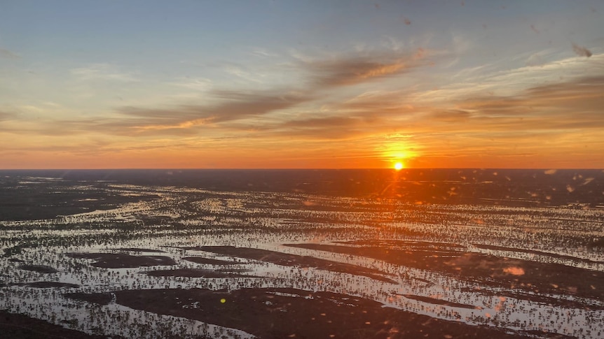The sun rises over flooded channels in outback Queensland.