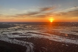 The sun rises over flooded channels in outback Queensland.