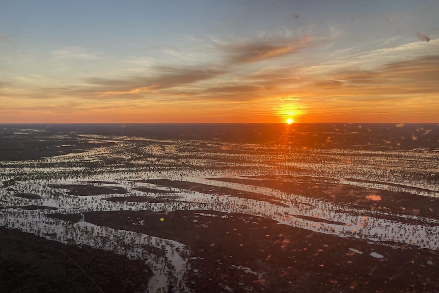 The sun rises over flooded channels in outback Queensland