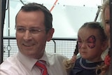 Mark McGowan with his family boards the bus