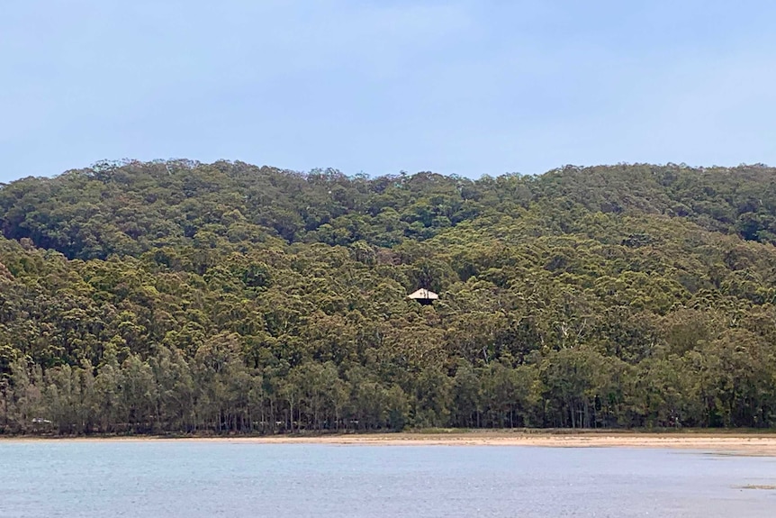 The holiday house in Tarbuck Bay the Matchett family was staying at, seen from the water. It is surrounded by dense bush.