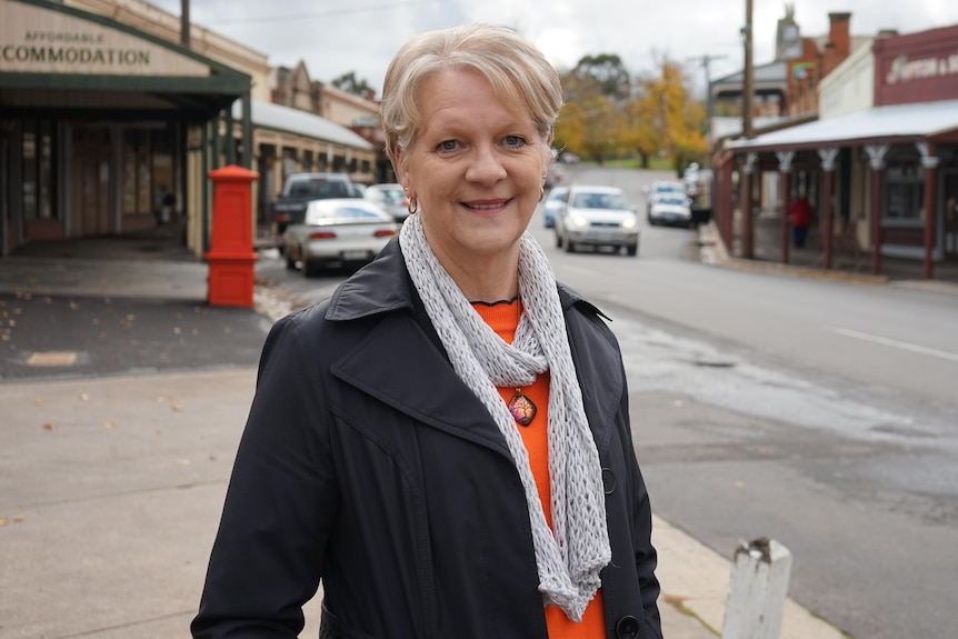 a woman with blonde hair smiles at the camera