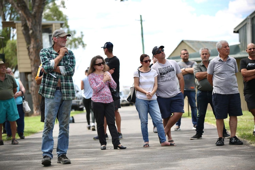 A group of men and women stand together