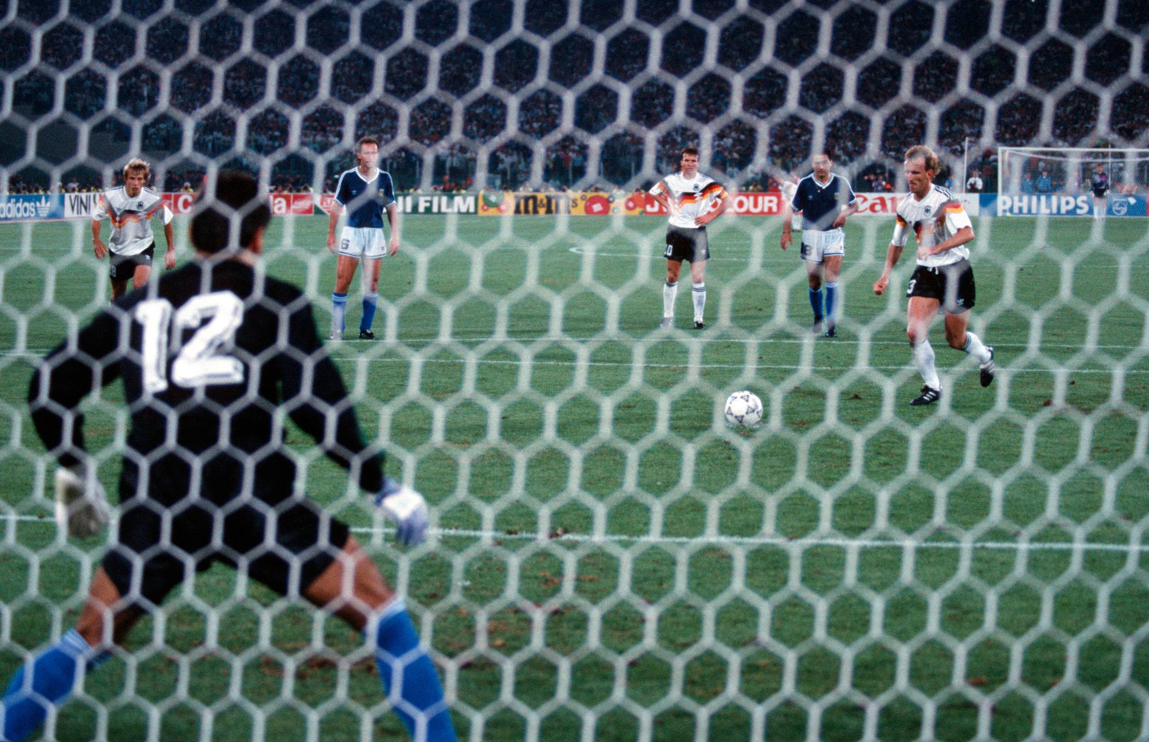 A German footballer runs up to take a penalty in a World Cup final as the goalkeeper stands on the goal line.