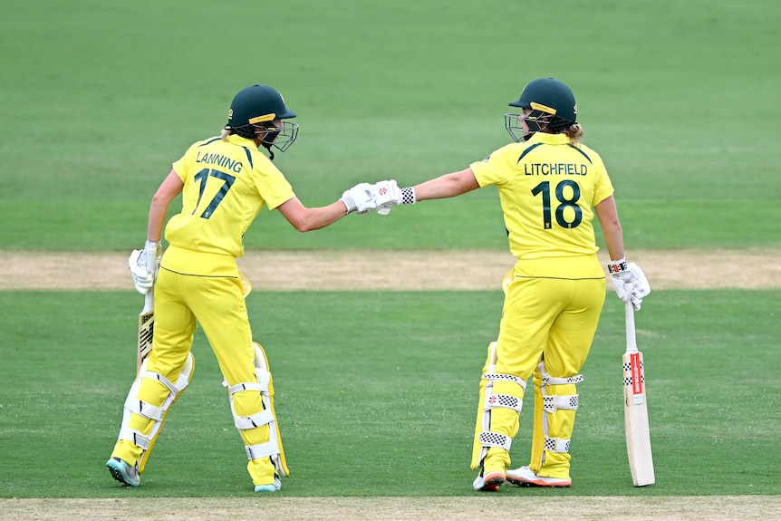Две женщины празднуют во время матча по крикету