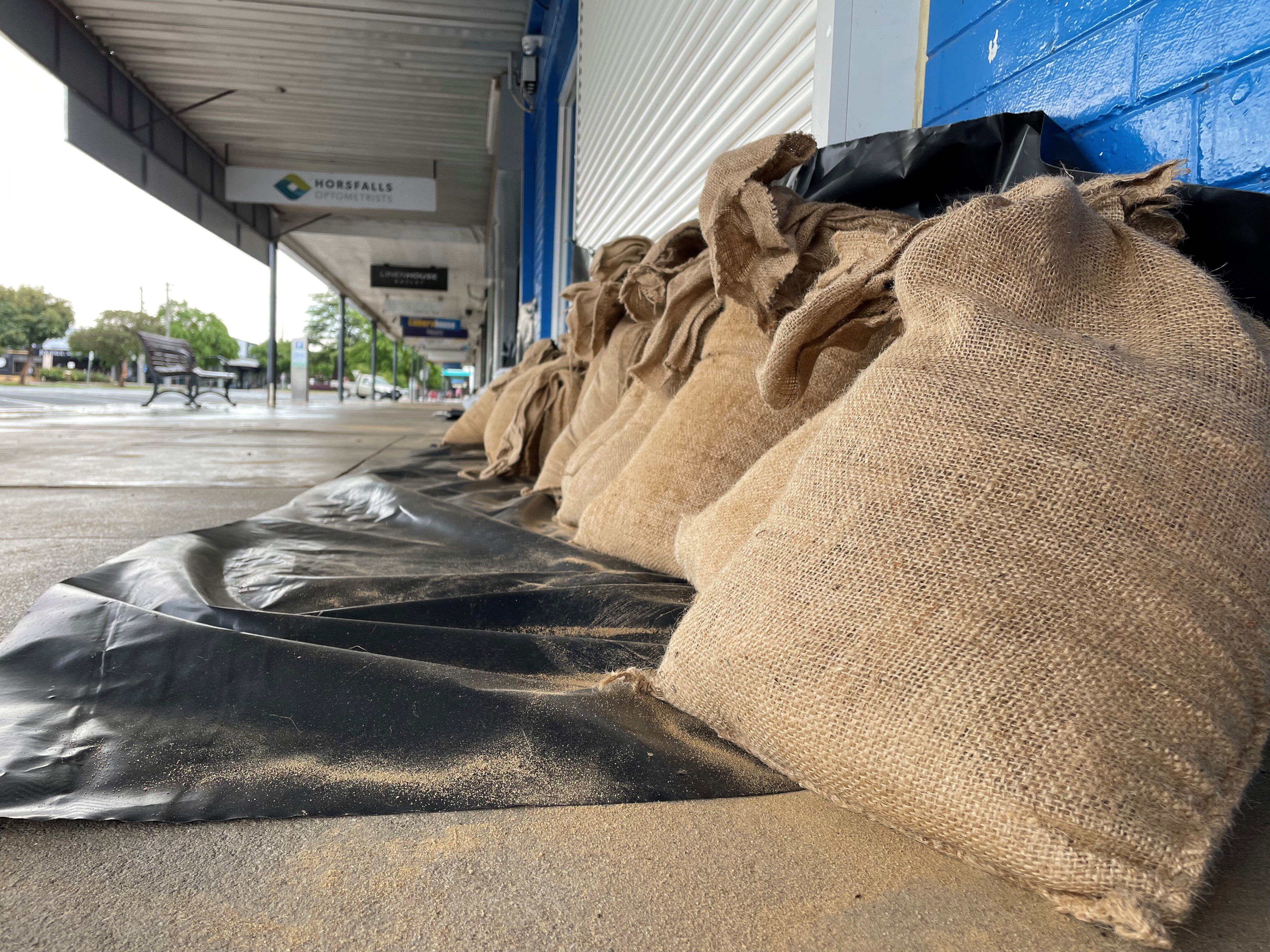 sandbags along the ground in front of shops