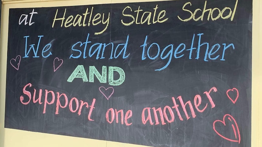 A sign on a blackboard reads "we stand together".