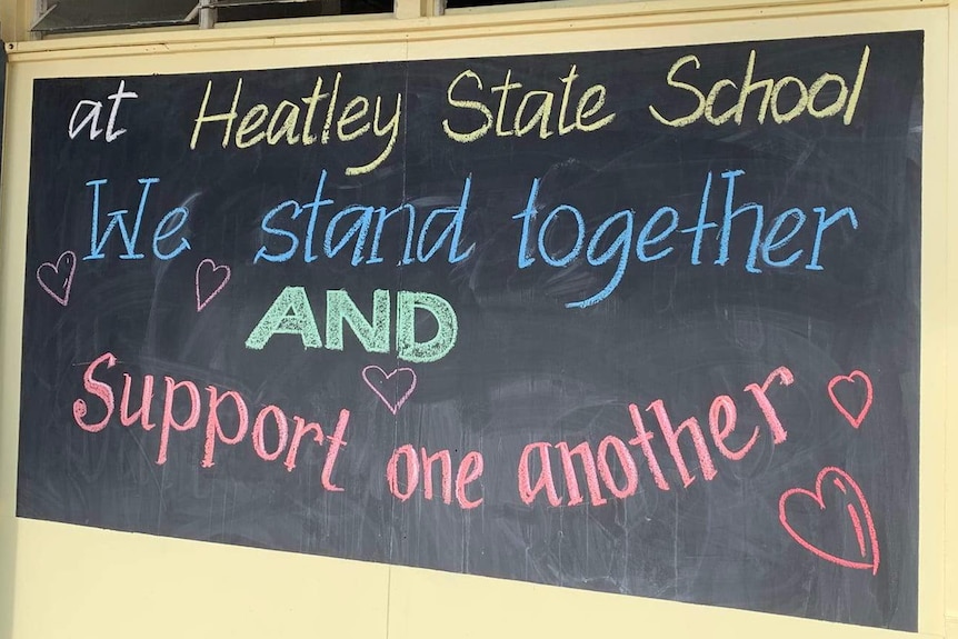 A sign on a blackboard reads "we stand together".