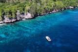 A boat sits in pristine waters off Christmas Island.
