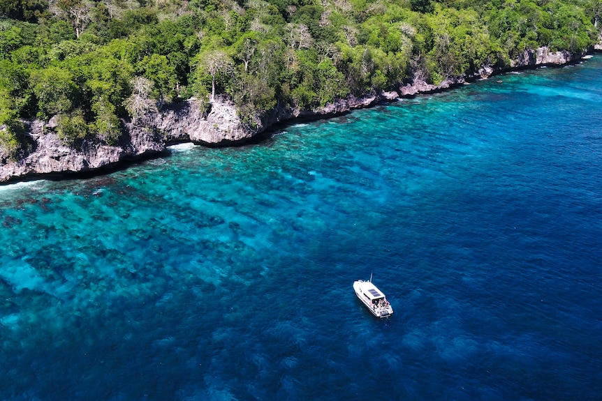 A boat sits in pristine waters off Christmas Island.