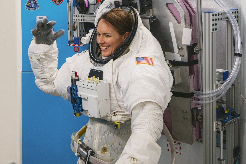 Katherine Bennell-Pegg stands wearing a spacesuit.