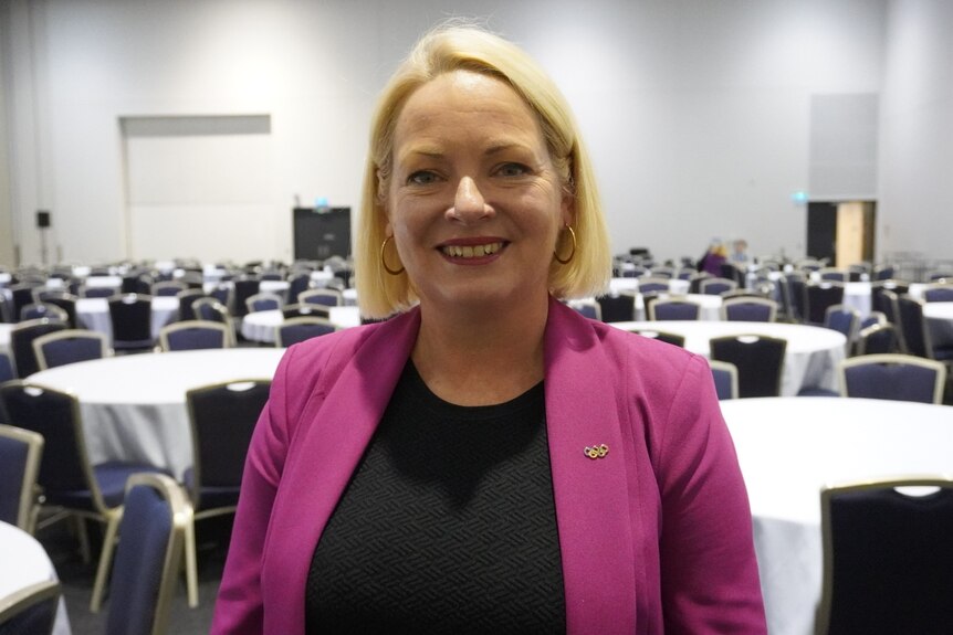 Krista Adams standing in front of tables and chairs at the LNP convention.