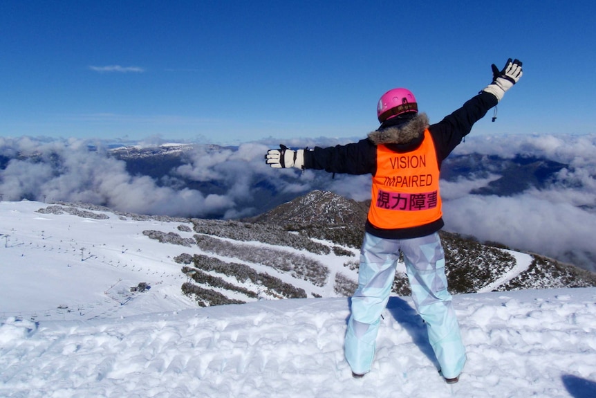Skier standing at the summit of a snow covered mountain