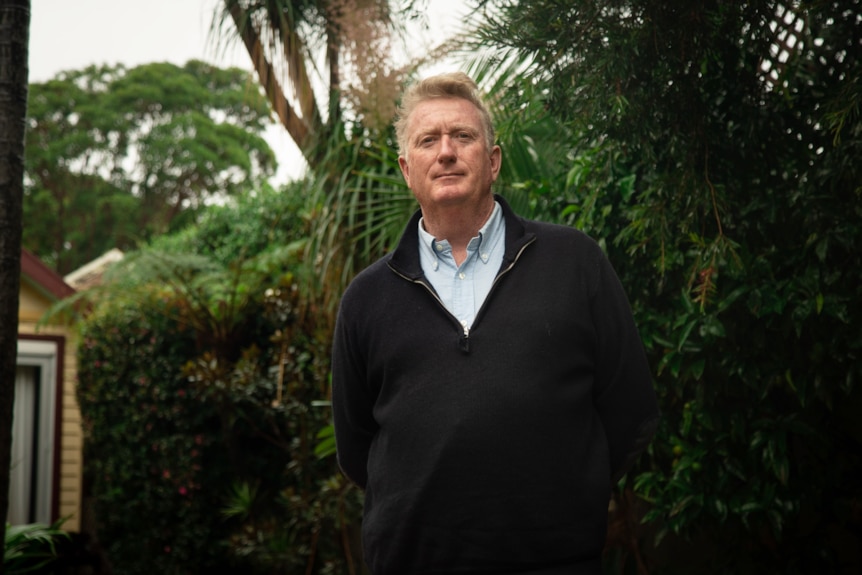 Tom Hubble stands in a backyard.