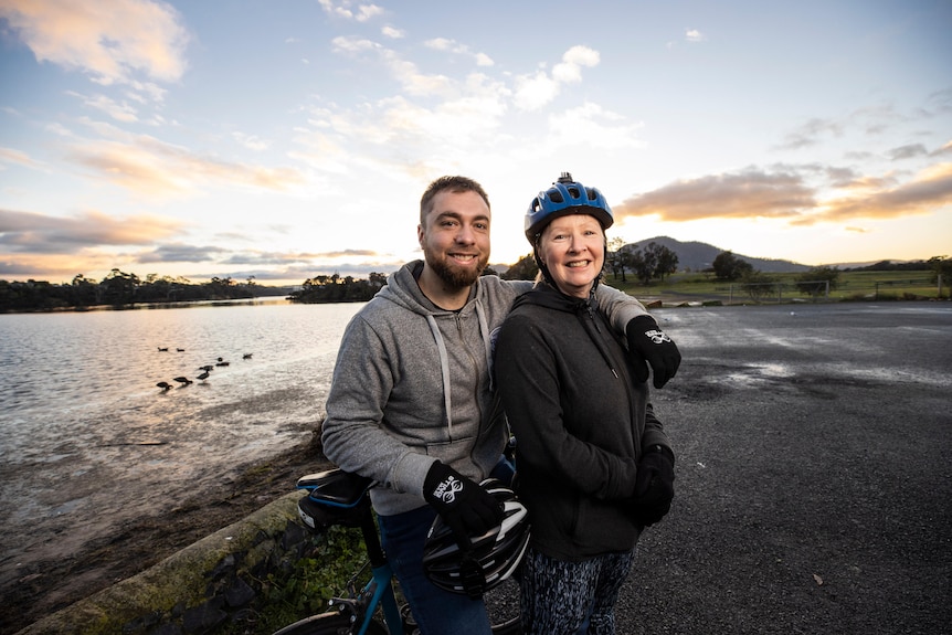 Un homme et une femme se tenant, portant des casques de vélo.