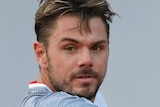 Stan Wawrinka holds his racquet in his right hand and prepares to play a back-hand shot while watching the ball in front of him