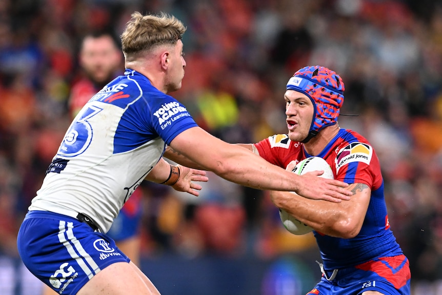 Newcastle Knights' Kalyn Ponga tries to fend off Canterbury Bulldogs' Max King.