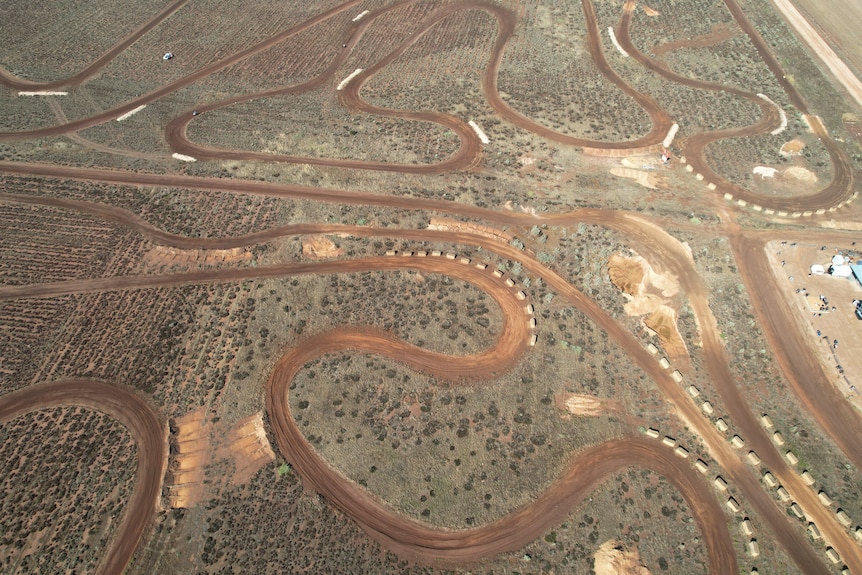 An aerial view of a dirt racetrack on a property.