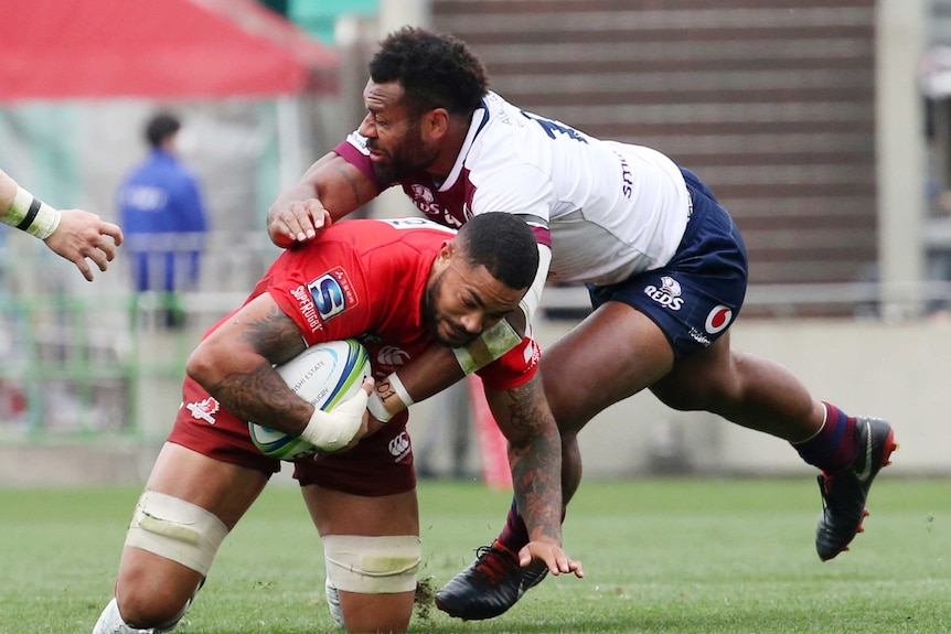 Rahboni Warren-Vosayaco on his knees holding the ball, as he is tackled by Samu Kerevi.