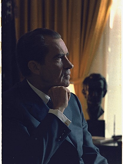 Richard Nixon sitting in the White House Oval Office