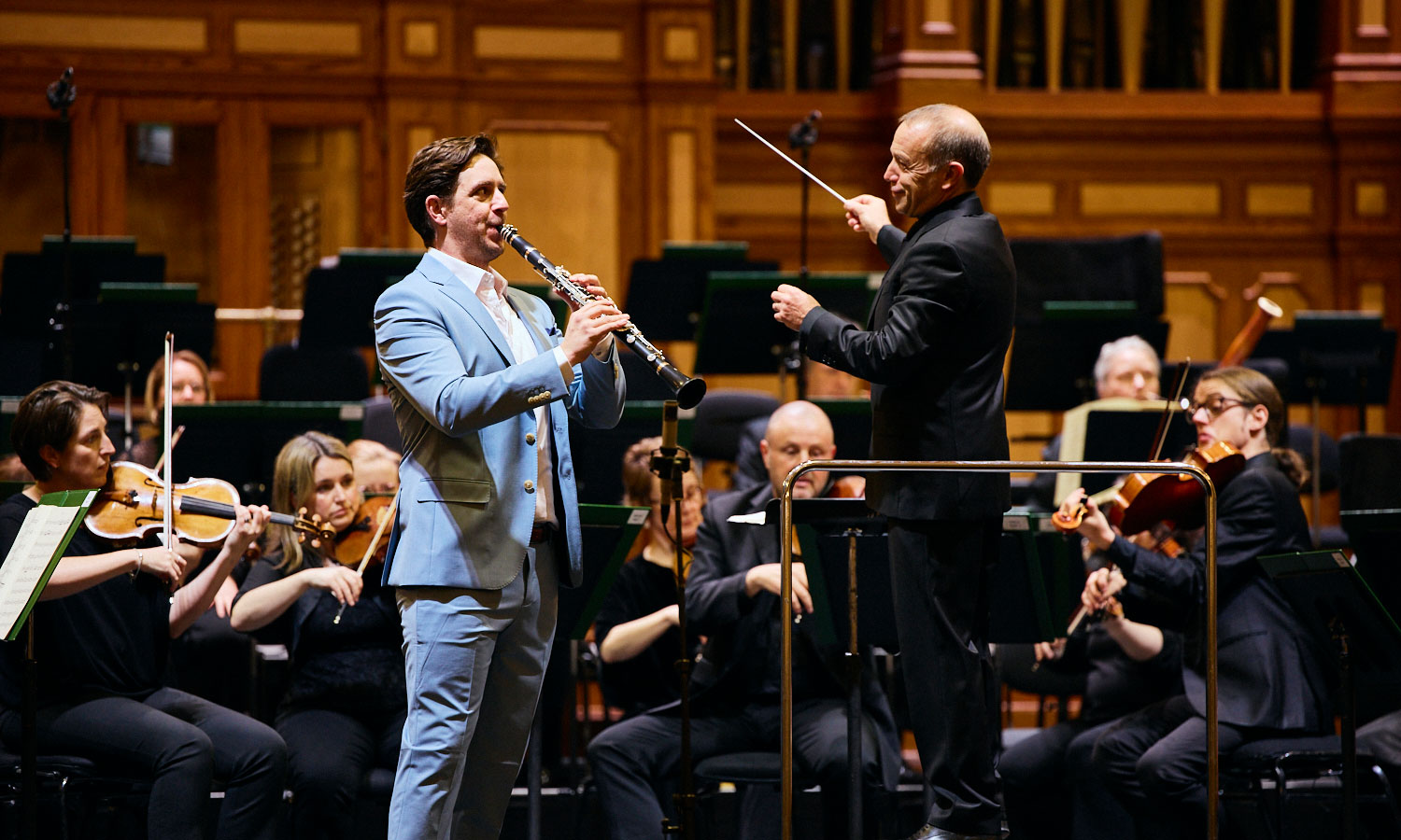 ASO Principal Clarinettist Dean Newcombe performing as soloist, with an orchestra behind him.