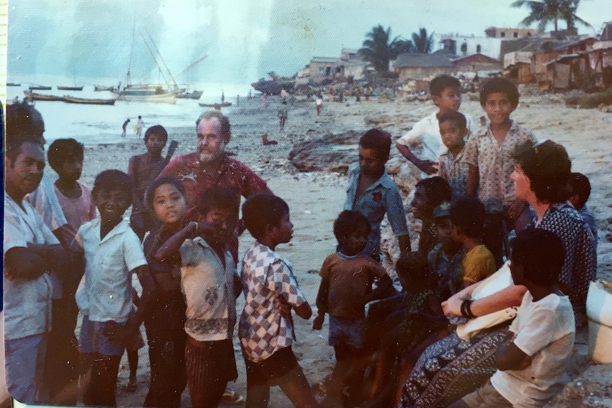 Les gens se rassemblent au bord de la mer, certains d'entre eux sont des enfants