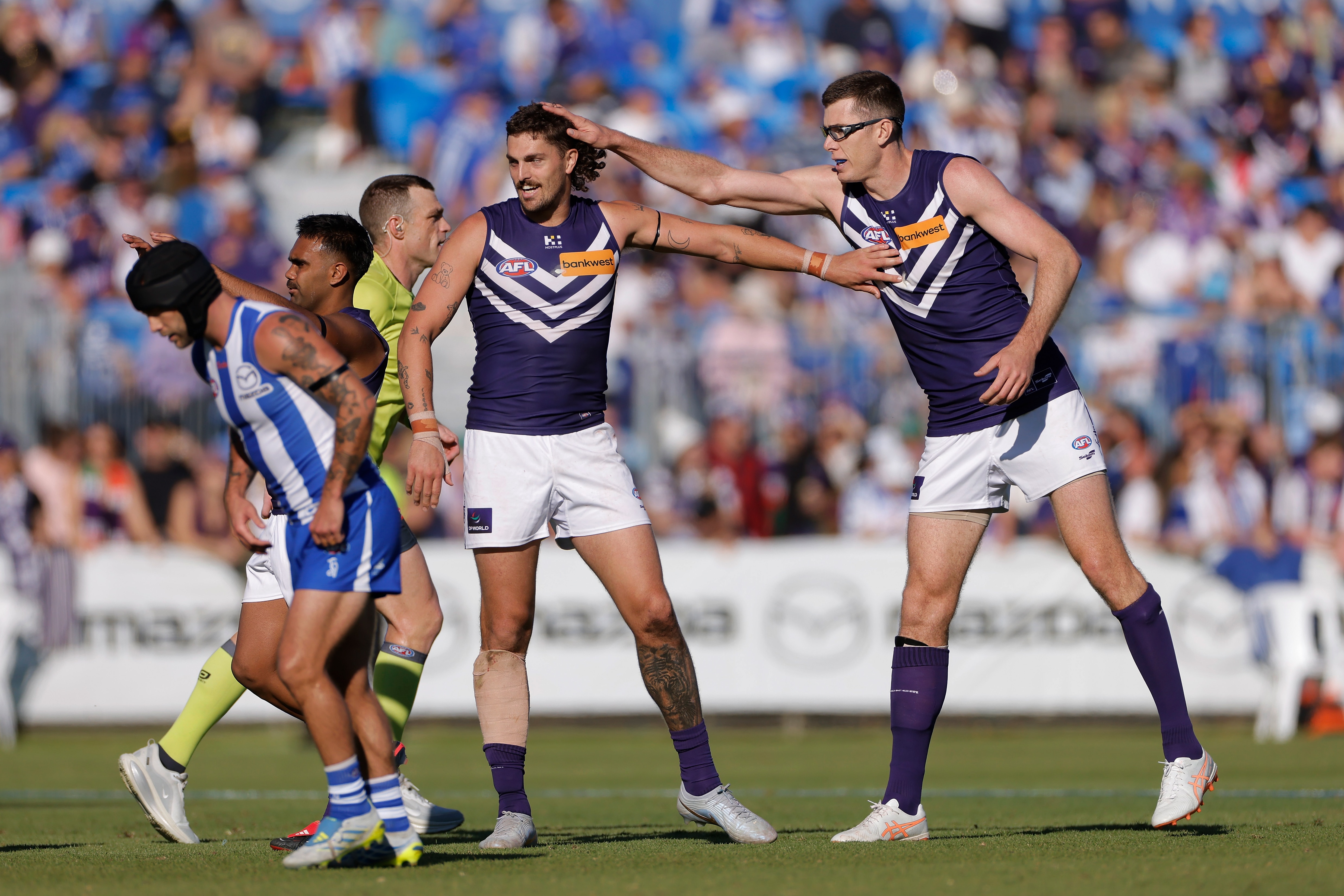 Mason Cox (glasses) pats Luke Jackson's head in congratulations during a game.