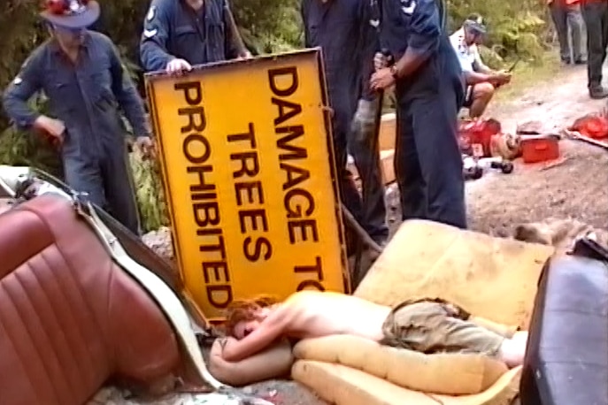 A man lies on the ground surrounded by police.