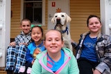 Ajax the Labrador sitting with four students at Trundle Central School