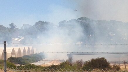 A helicopter can be seen fighting a fire in Perth's western suburbs.