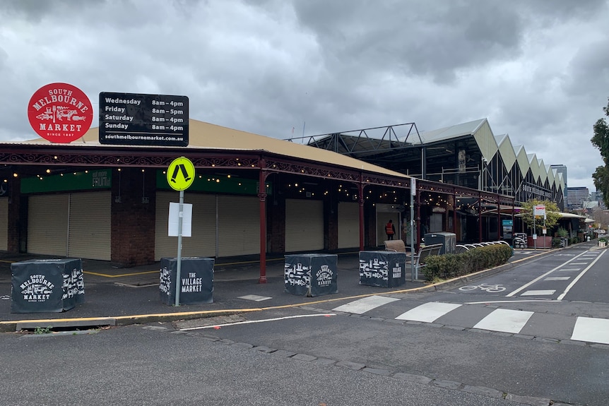 A cloudy grey sky hangs over a closed South Melbourne Market, viewed from the street.