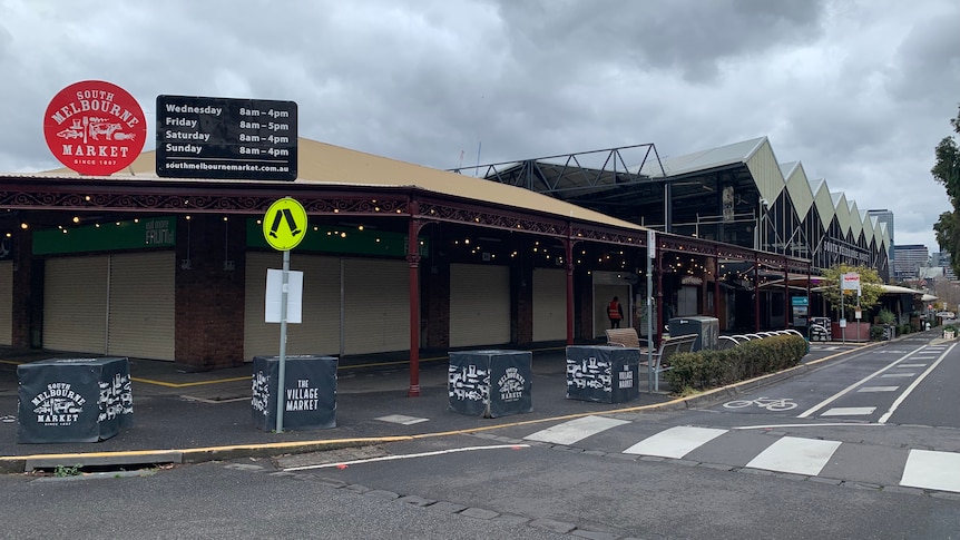 A cloudy grey sky hangs over a closed South Melbourne Market, viewed from the street.