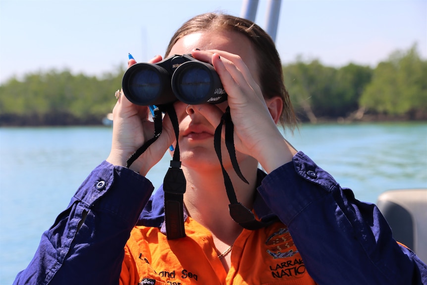 Senior Aboriginal ranger Gabriel Miller looks for birds through binoculars. 