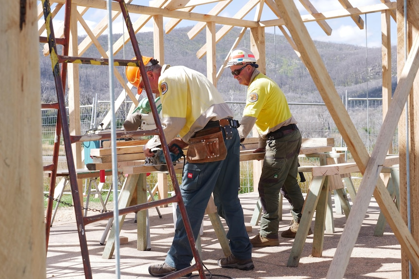 Two NSW National Parks and Wildlife Service staff rebuilding a historic hut