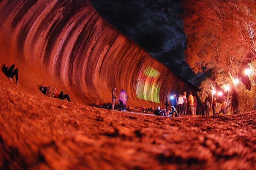 giant red wave with people near 