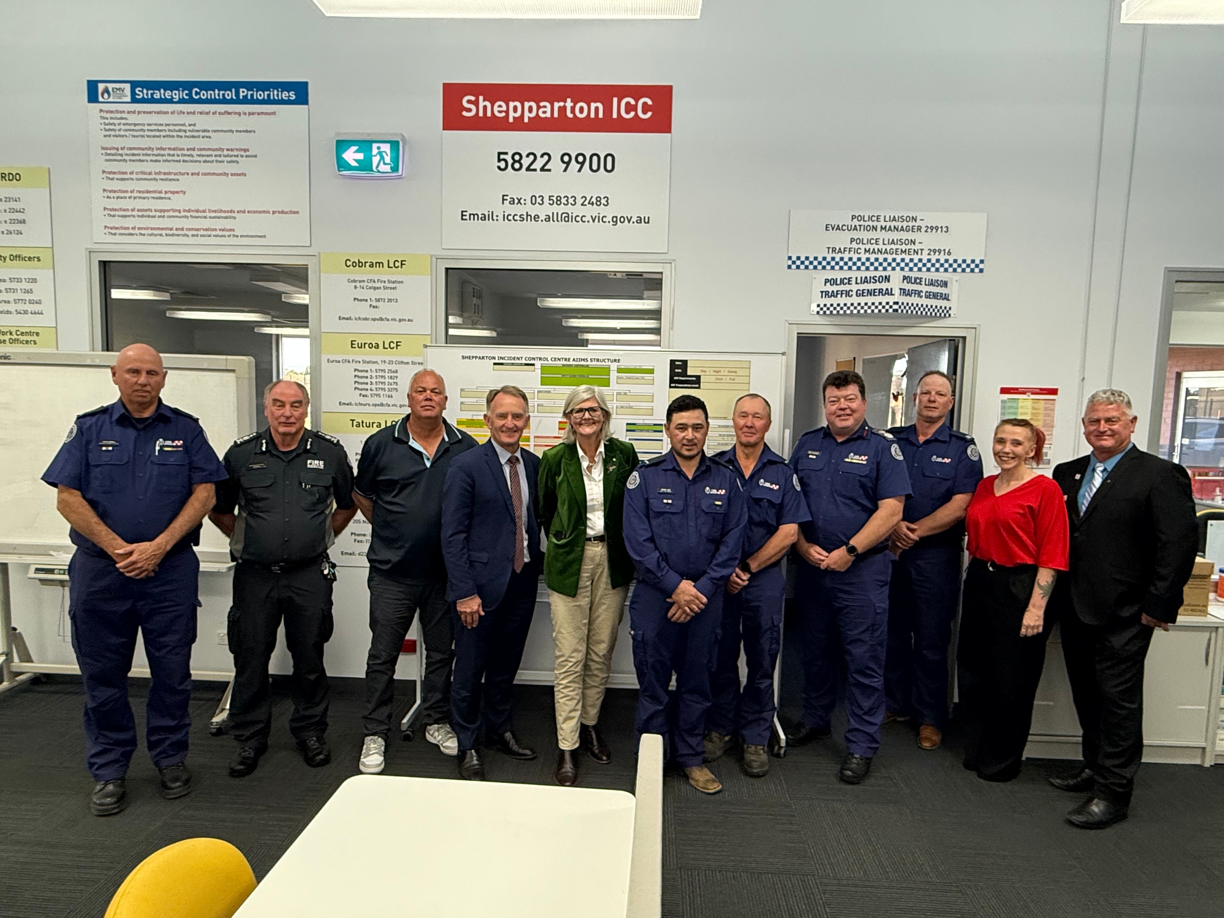 people gather for a group photo in an emergency control centre.
