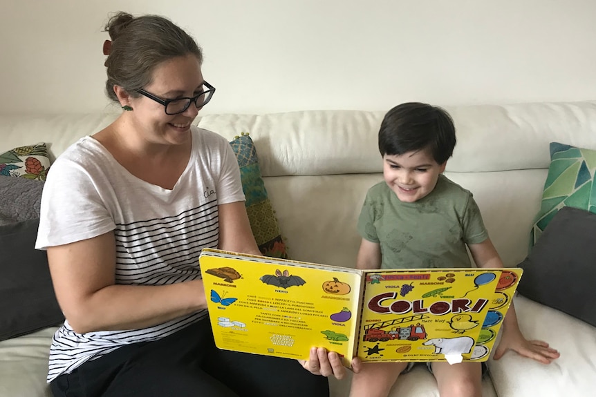 A woman reads an Italian book with her son